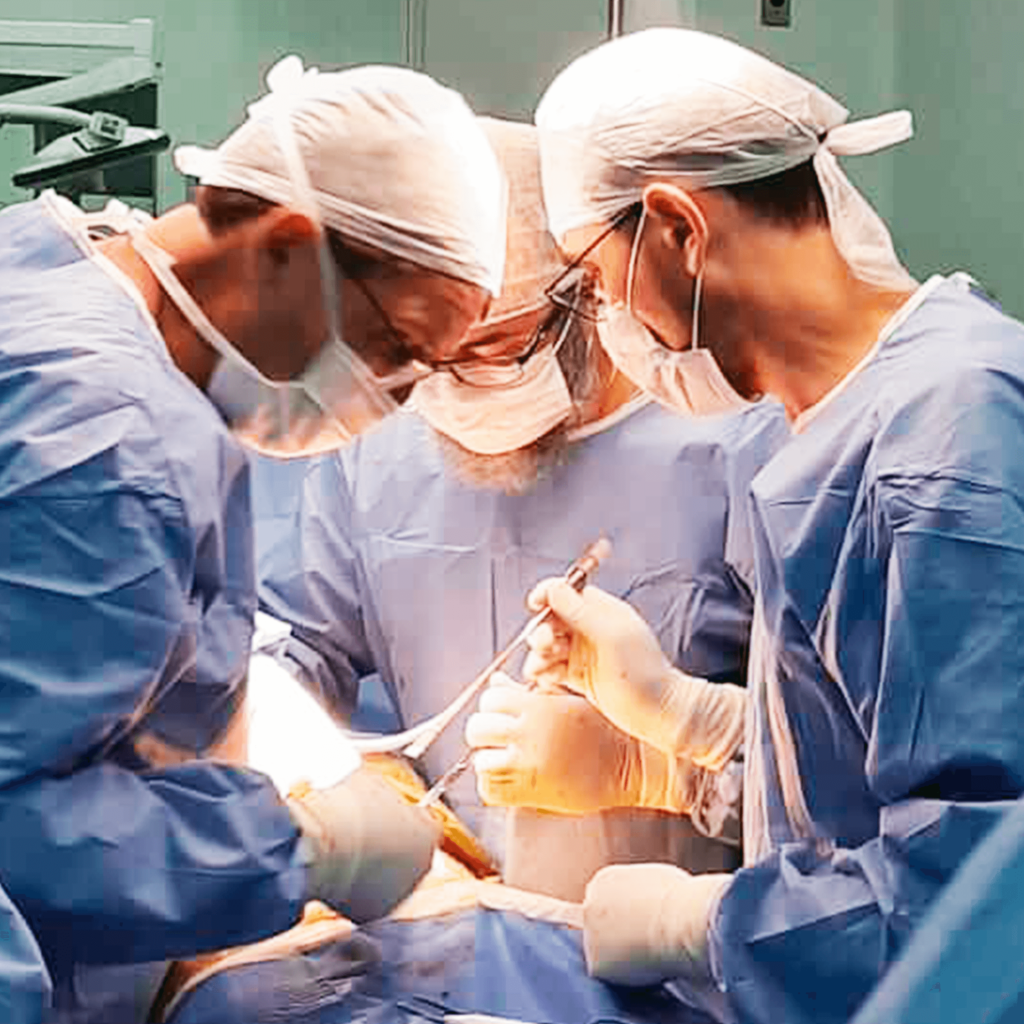 Três cirurgiões em meio a cirurgia